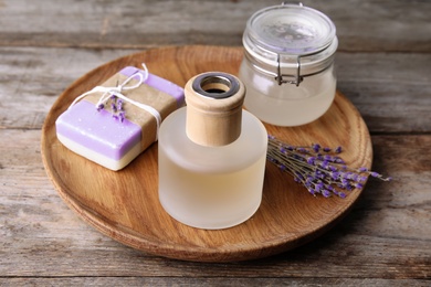 Photo of Natural herbal oil, soap and lavender flowers on wooden background