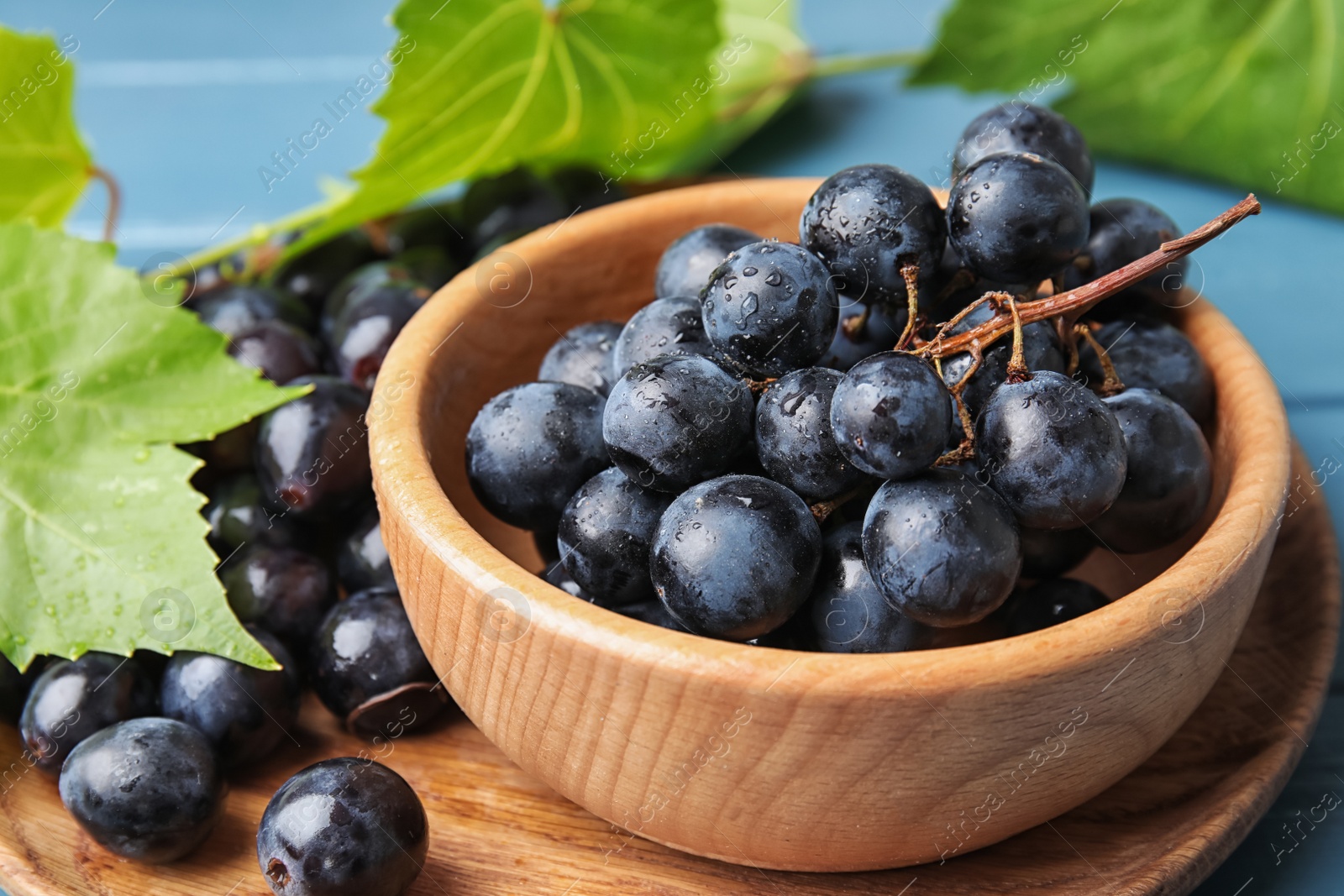 Photo of Fresh ripe juicy grapes in bowl on table, closeup