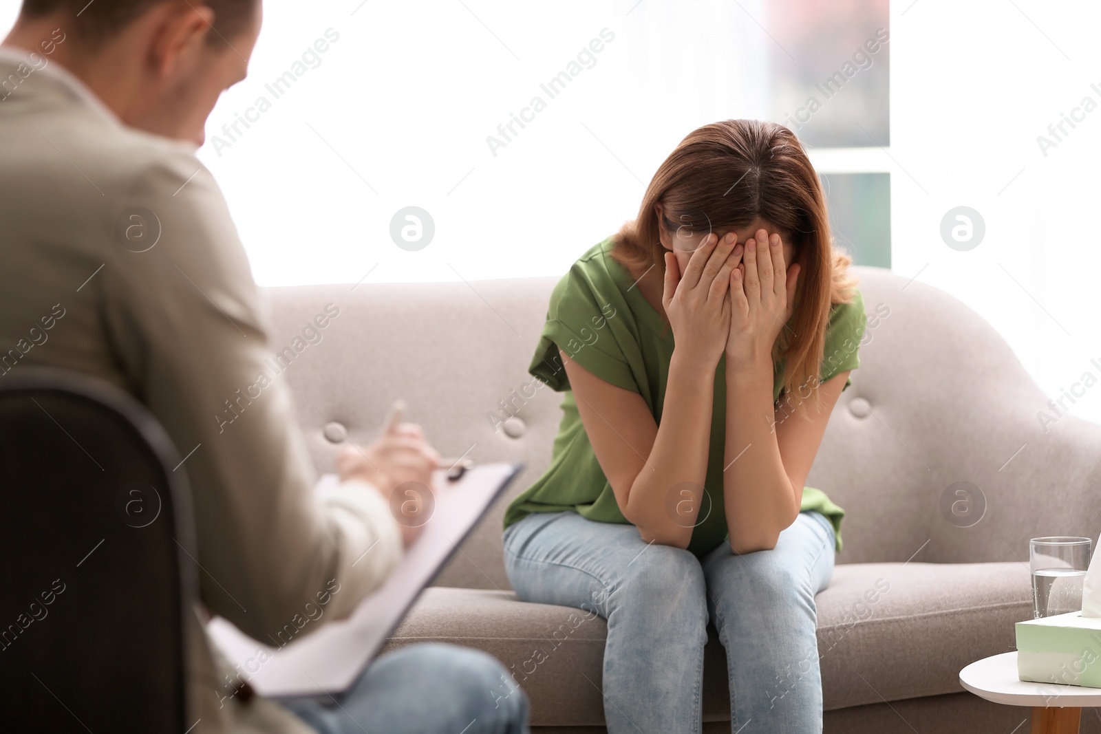 Photo of Psychotherapist working with woman in light office