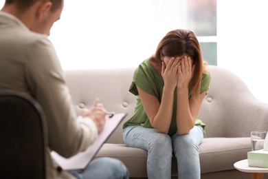 Photo of Psychotherapist working with woman in light office