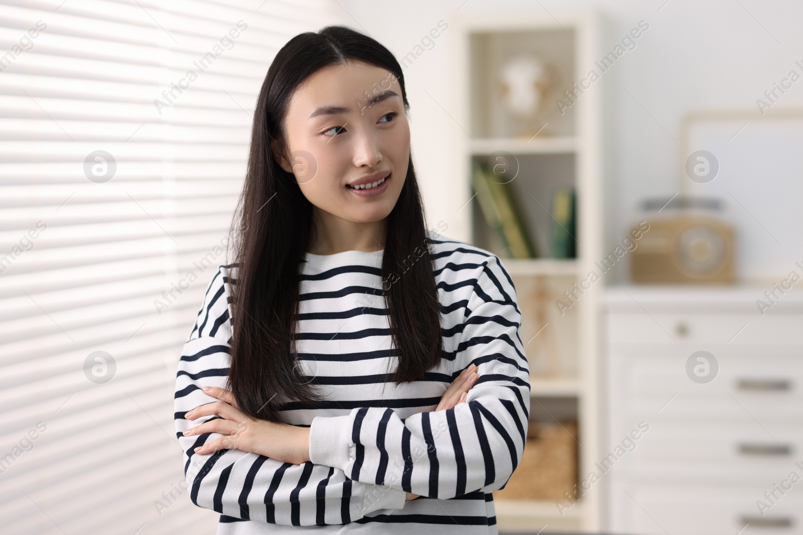 Photo of Portrait of smiling businesswoman with crossed arms in office