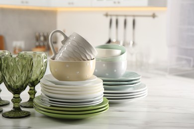 Photo of Many different clean dishware, glasses and cup on white marble table indoors. Space for text