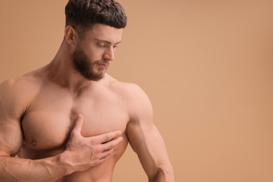 Handsome muscular man on beige background, space for text. Sexy body