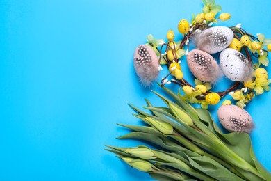 Flat lay composition with flowers and eggs on light blue background, space for text. Easter celebration