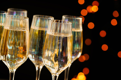 Photo of Glasses of champagne against blurred lights, closeup