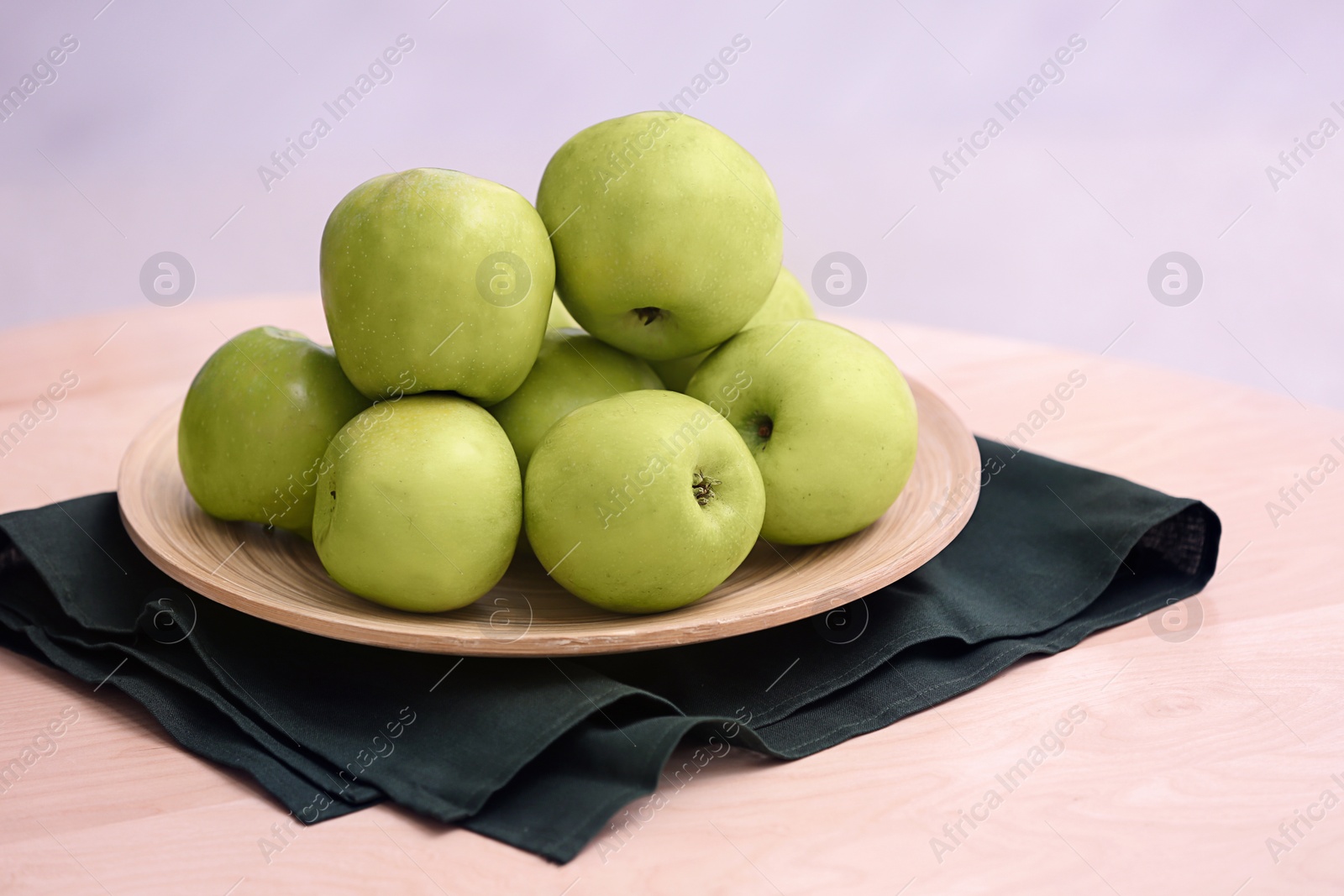 Photo of Plate with ripe green apples on table