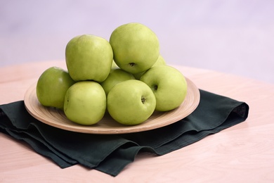 Photo of Plate with ripe green apples on table