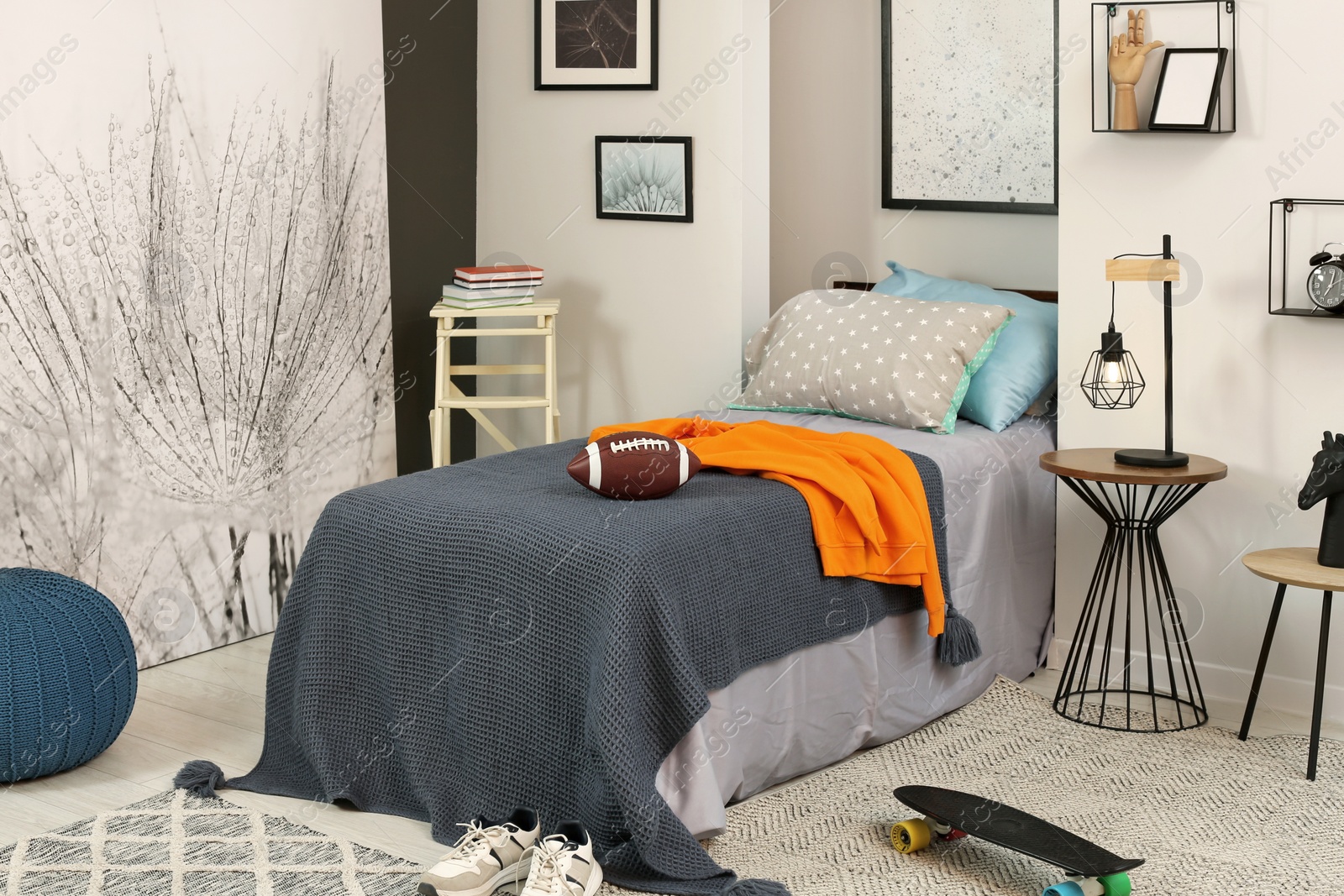 Photo of Stylish teenager's room interior with comfortable bed, lamp and football ball