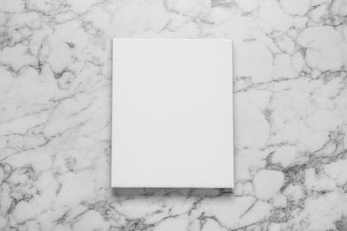 Blank canvas on white marble background, top view. Space for design