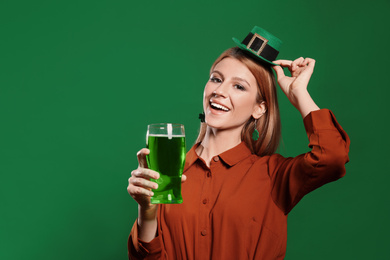 Photo of Young woman with green beer on color background. St. Patrick's Day celebration