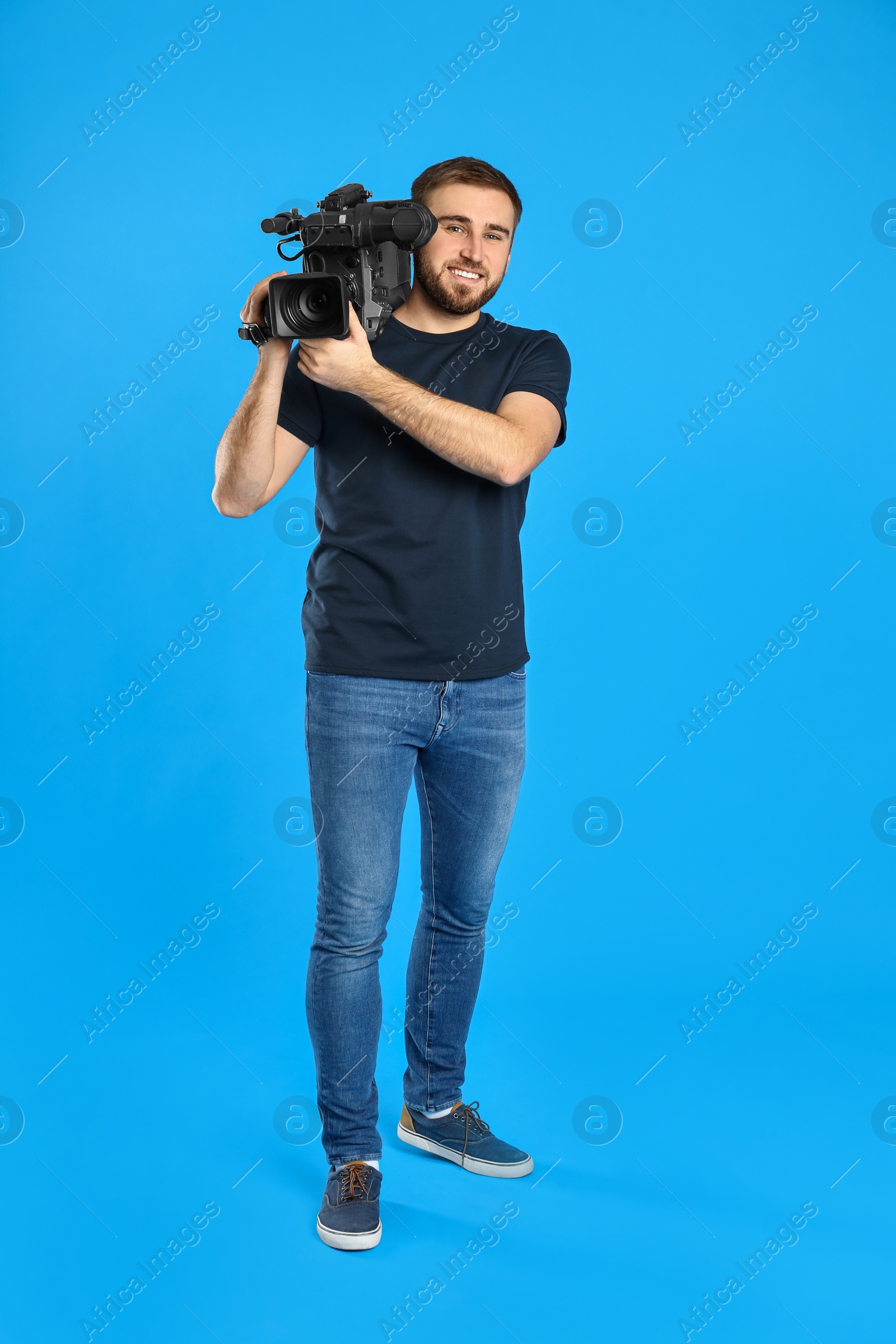 Photo of Operator with professional video camera on blue background