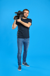 Operator with professional video camera on blue background