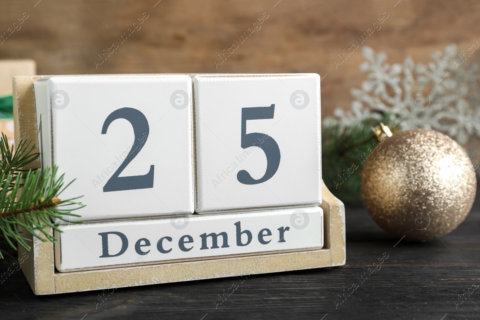 Photo of Block calendar and festive decor on black wooden table. Christmas countdown