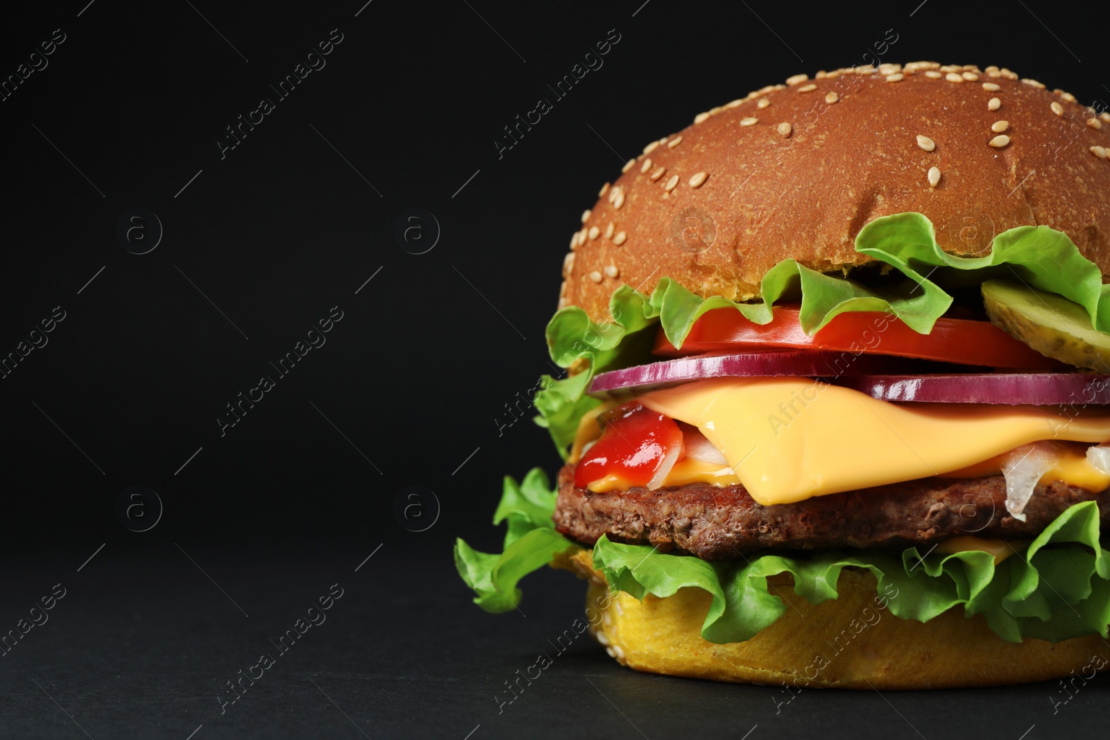 Photo of Delicious burger with beef patty and lettuce on dark background, space for text