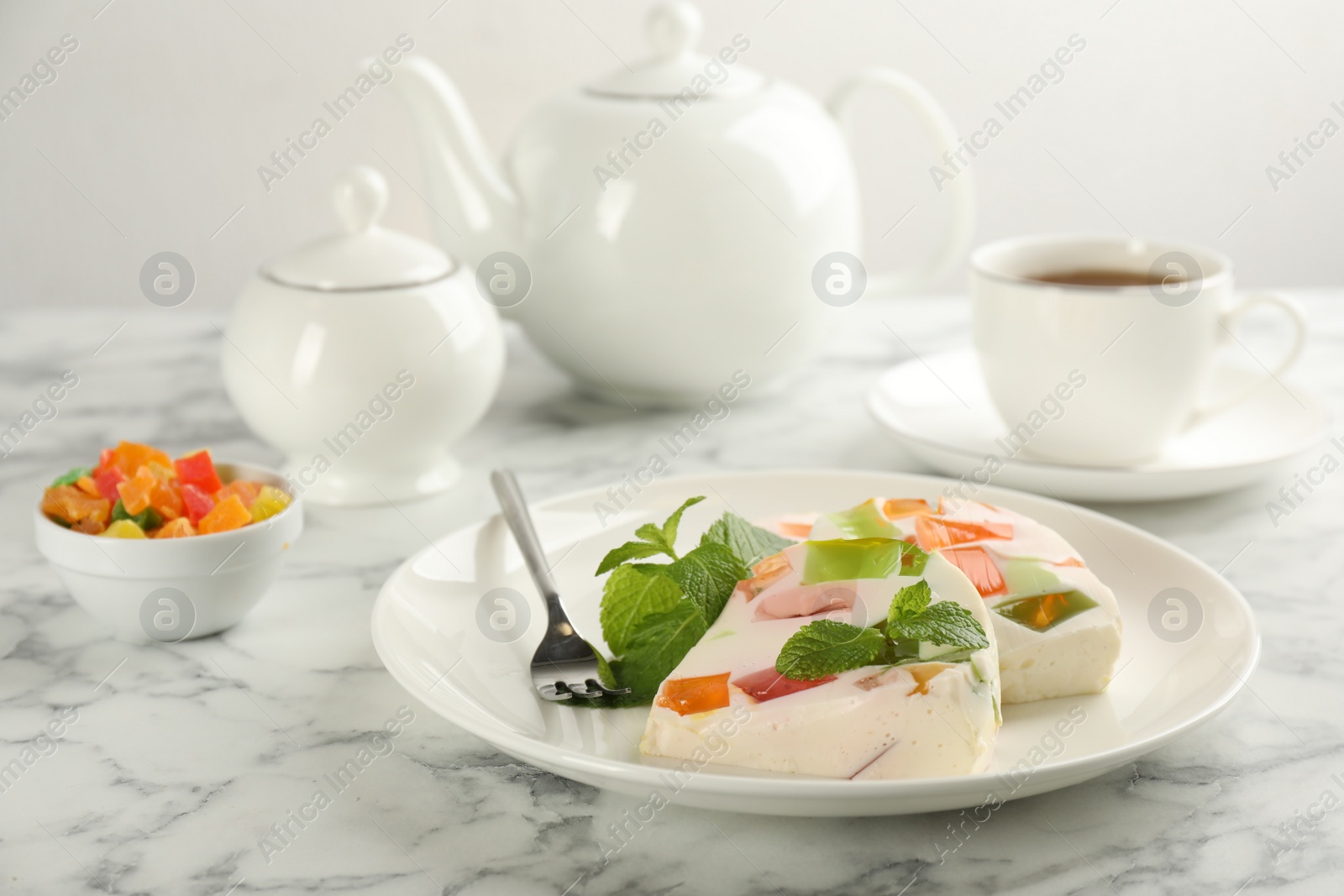 Photo of Delicious broken glass jelly dessert on white marble table