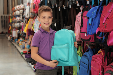 Little school boy with backpack in supermarket