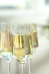 Glasses of champagne on blurred background, closeup view