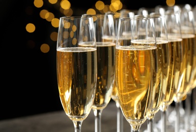 Photo of Many glasses of champagne on blurred background, closeup