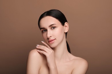 Portrait of beautiful young woman on brown background