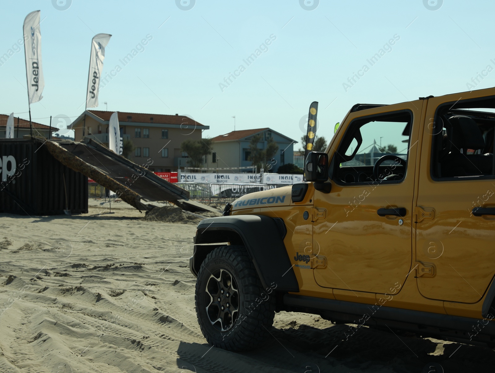Photo of SENIGALLIA, ITALY - JULY 22, 2022: Jeep test drive on sand outdoors. Car presentation
