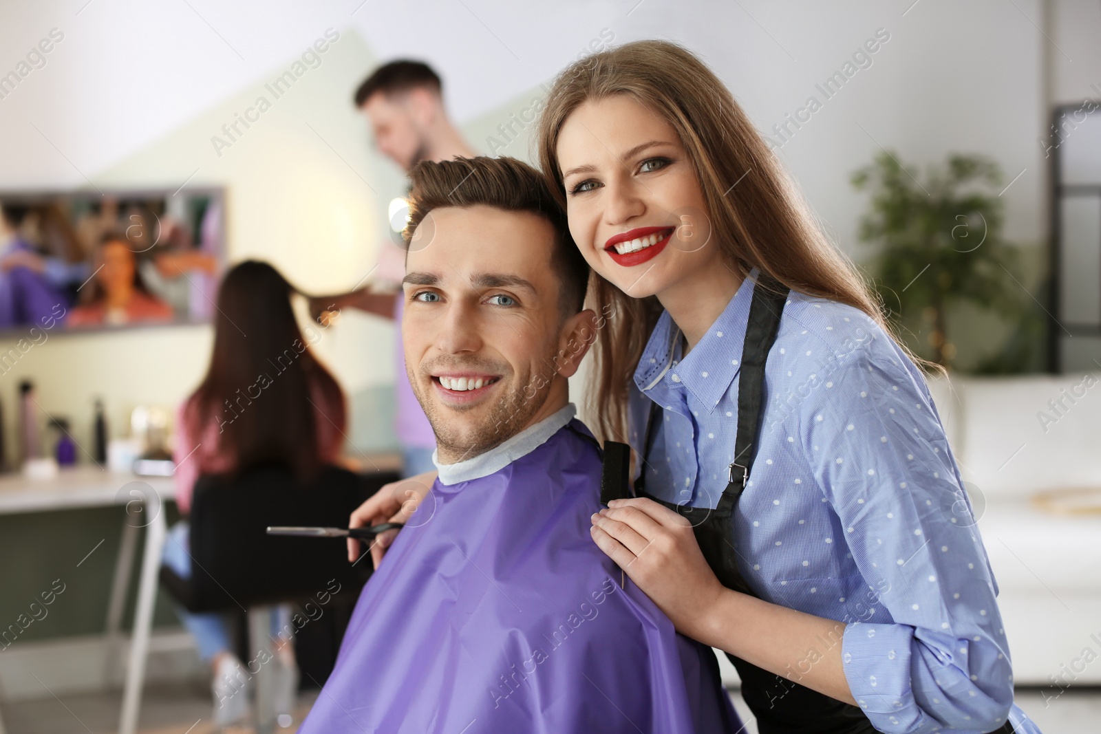 Photo of Hairdresser with happy client in beauty salon