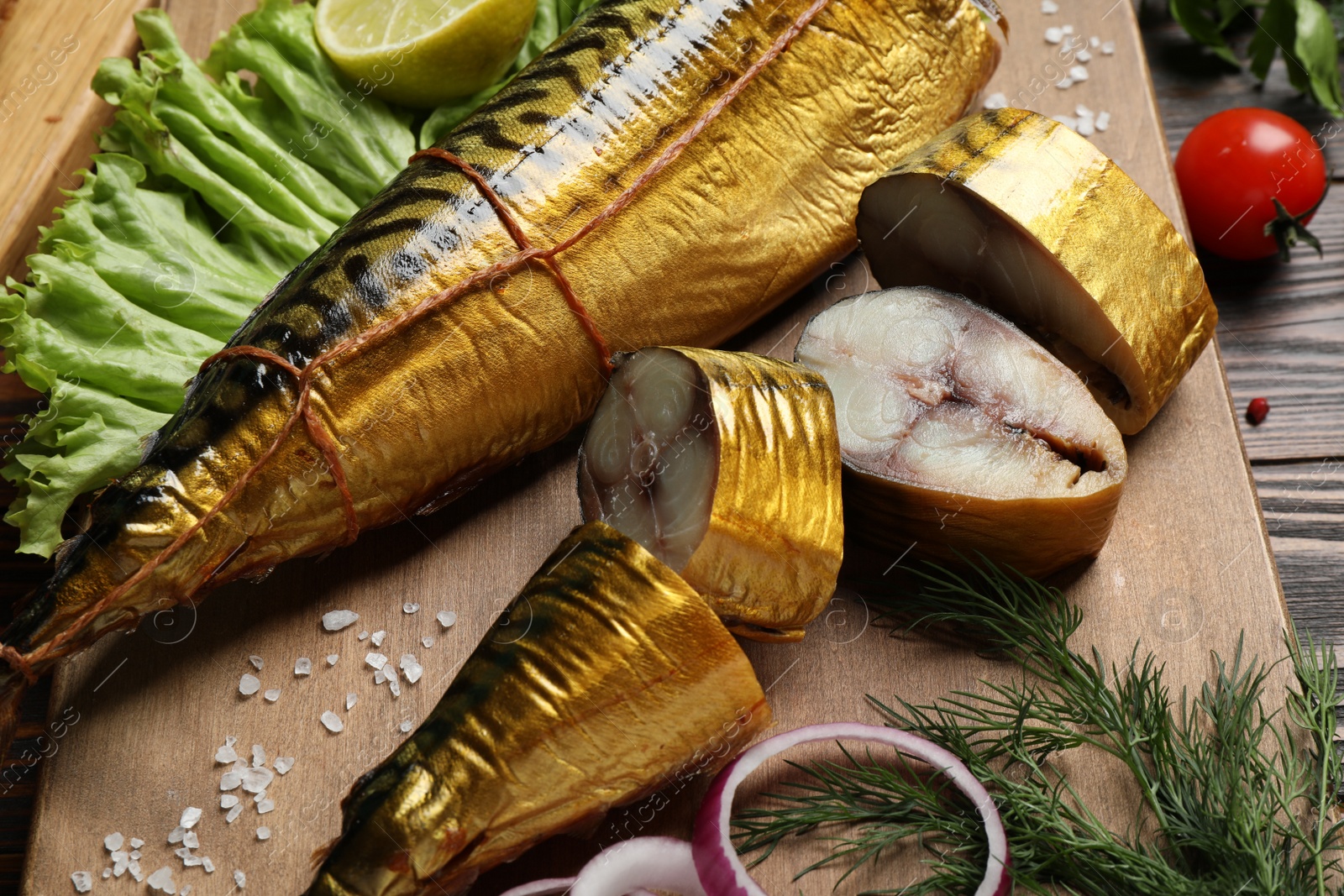 Photo of Tasty smoked fish on wooden table, closeup