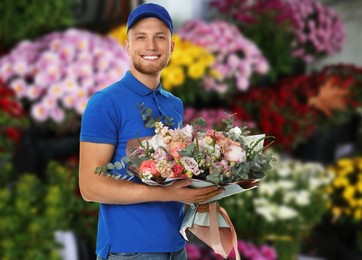 Delivery man with beautiful bouquet in flower shop