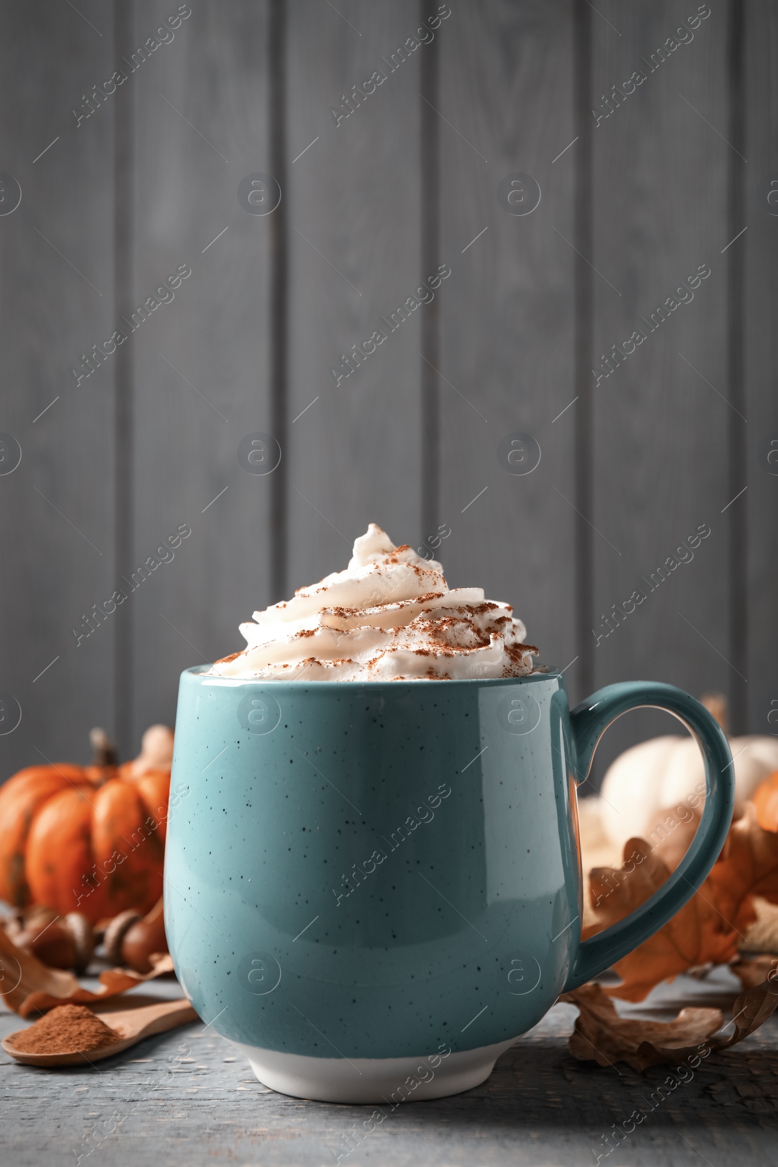 Photo of Delicious pumpkin latte on grey wooden table