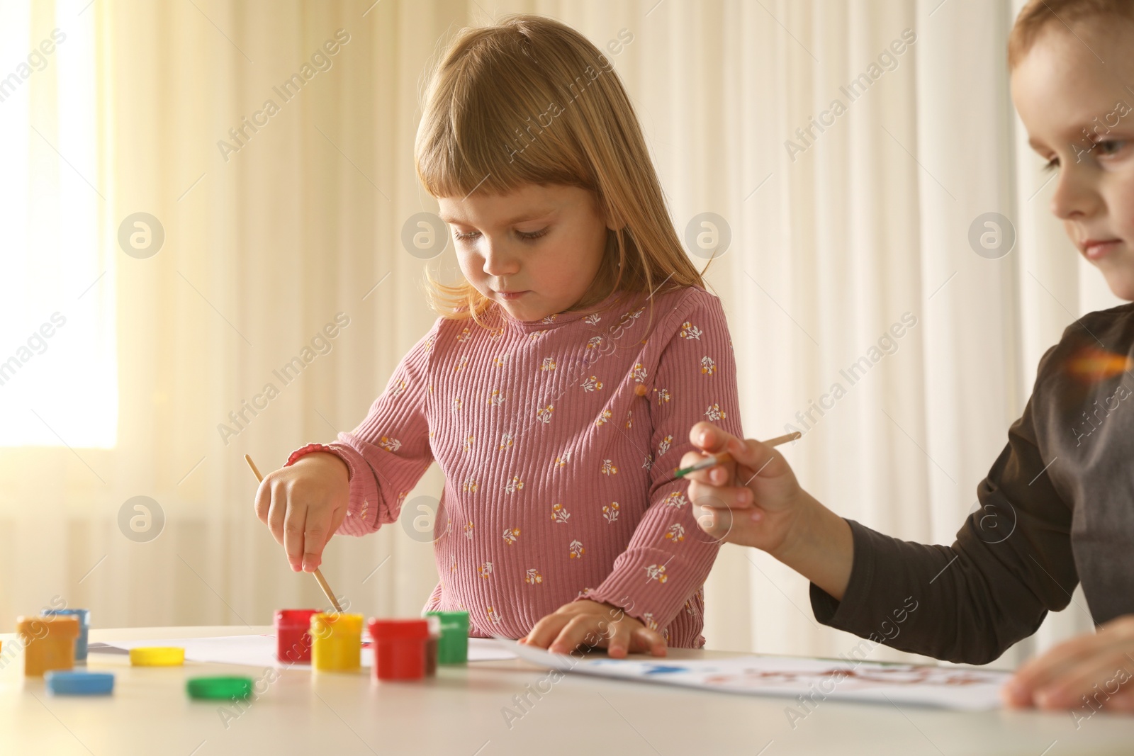 Photo of Cute little children drawing at light table indoors