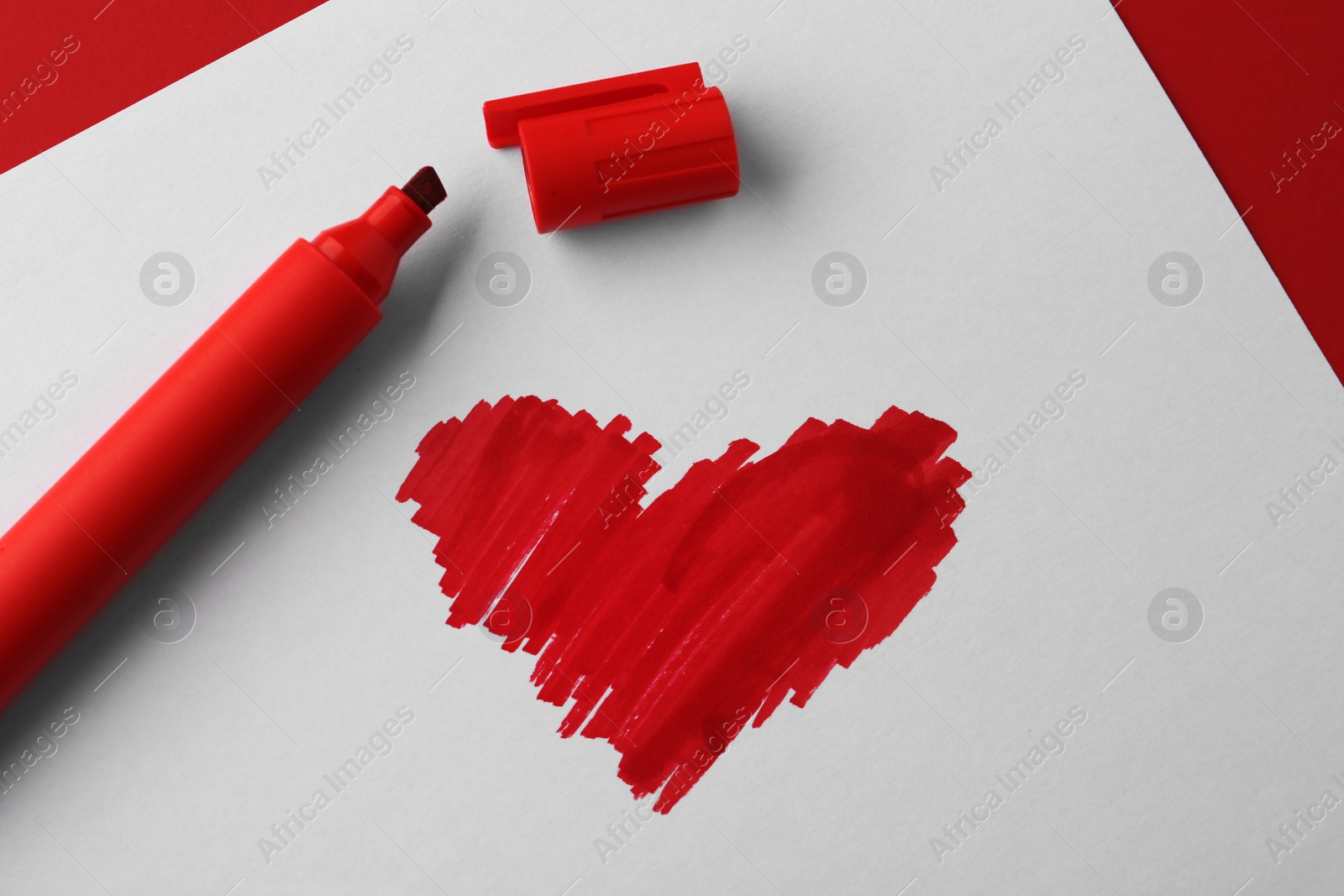Photo of Red heart drawn on white paper, top view