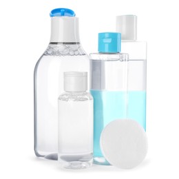 Photo of Bottles of micellar cleansing water and cotton pad on white background