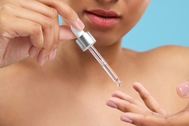 Photo of Woman applying serum onto her finger, closeup