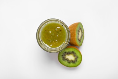 Photo of Tasty canned kiwi jam and fresh fruits on white background, top view