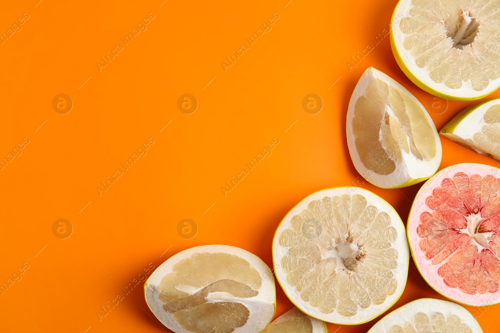 Photo of Fresh cut pomelo fruits on orange background, flat lay. Space for text