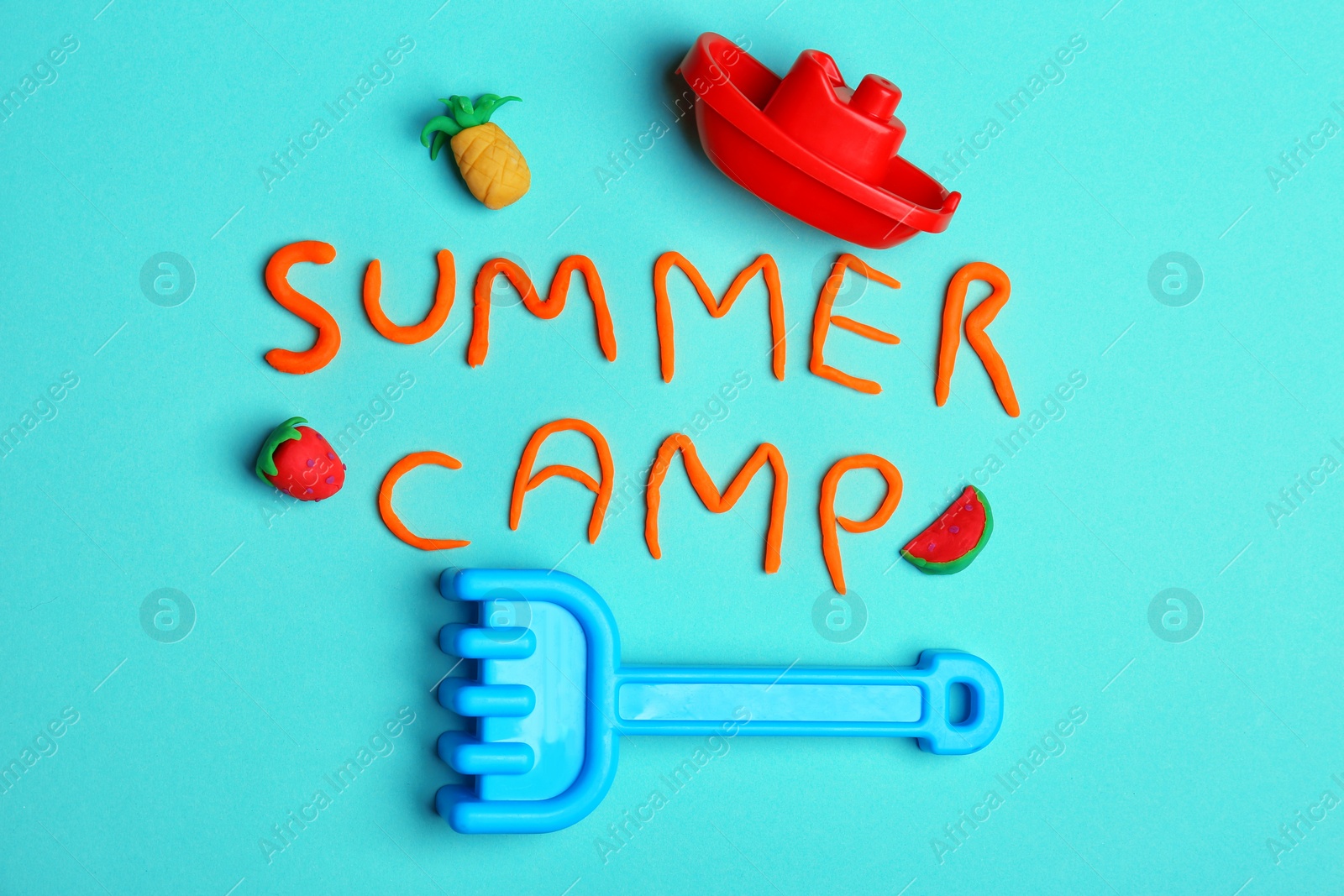 Photo of Flat lay composition with words SUMMER CAMP made from modelling clay and beach toys on color background