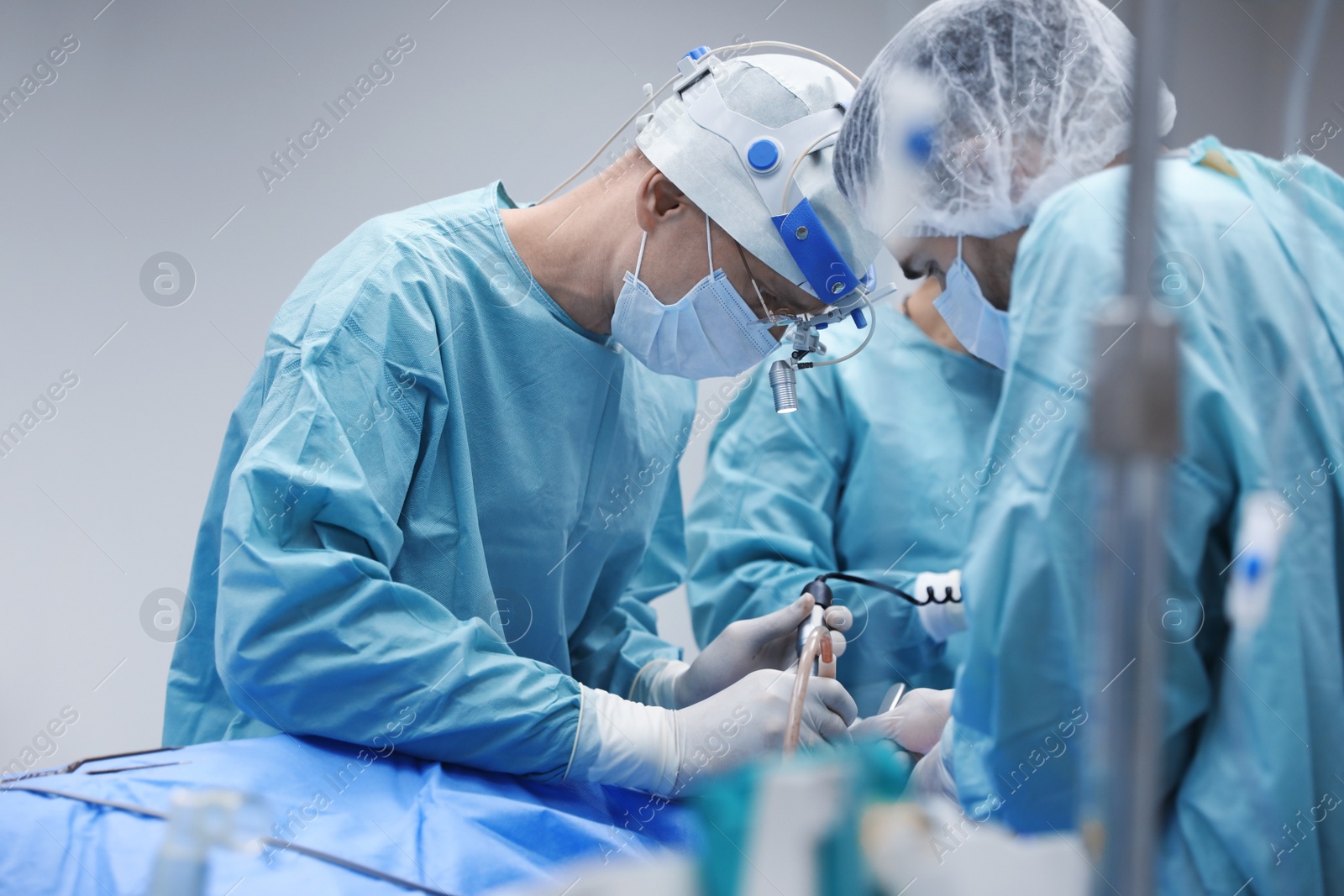 Photo of Team of professional doctors performing operation in surgery room