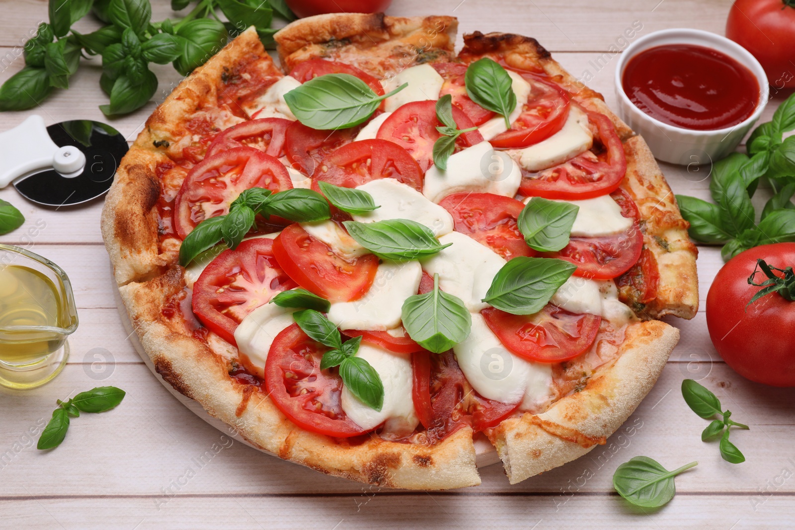Photo of Delicious Caprese pizza with tomatoes, mozzarella and basil on light wooden table