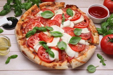 Photo of Delicious Caprese pizza with tomatoes, mozzarella and basil on light wooden table