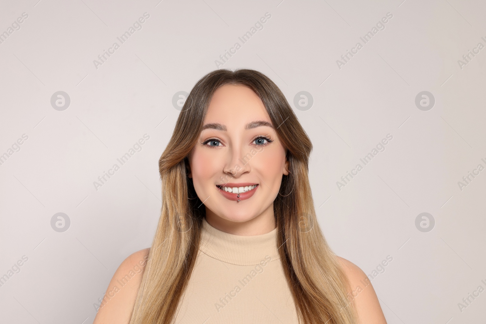 Photo of Young woman with lip piercing on white background