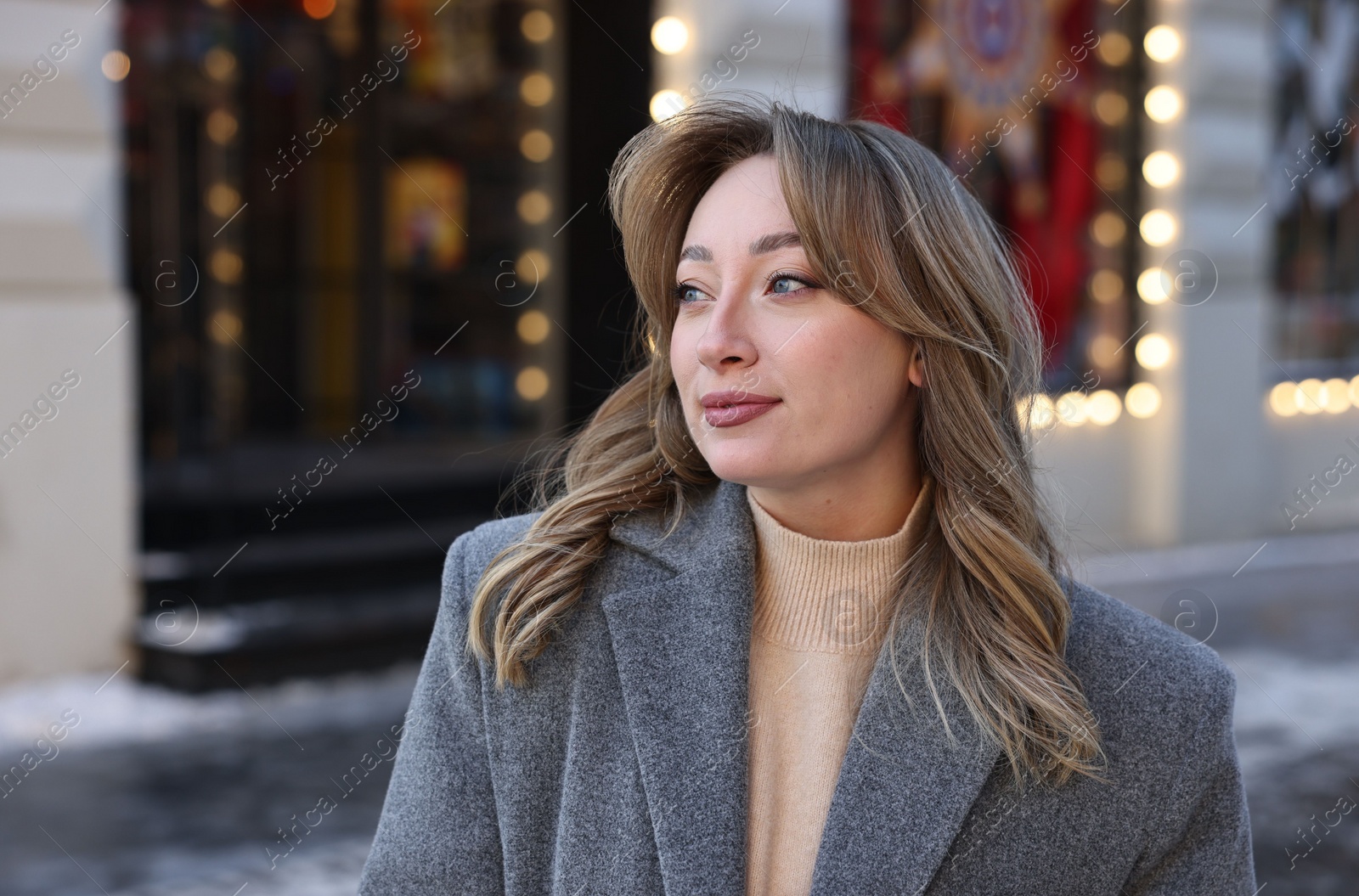 Photo of Portrait of charming woman on city street in winter. Space for text