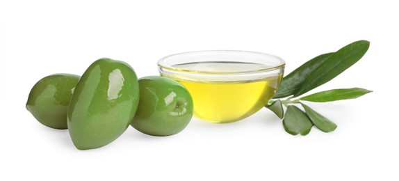 Photo of Cooking oil in glass bowl, olives and leaves on white background