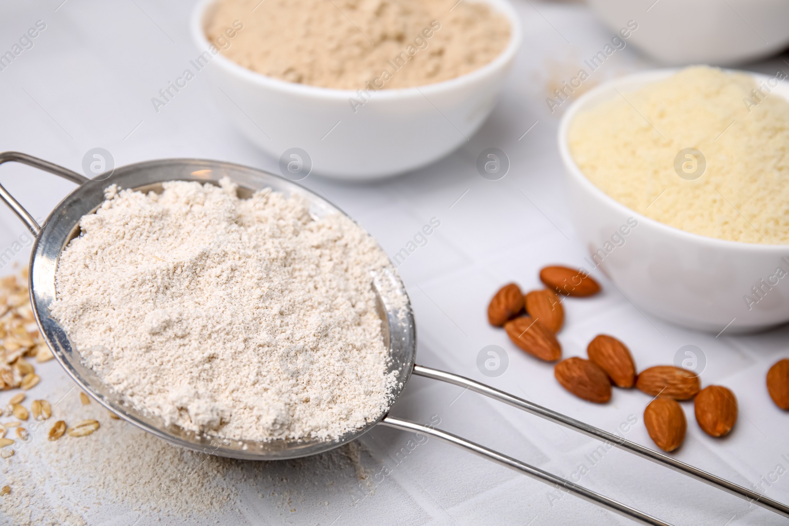 Photo of Different types of flour on tiled table, closeup