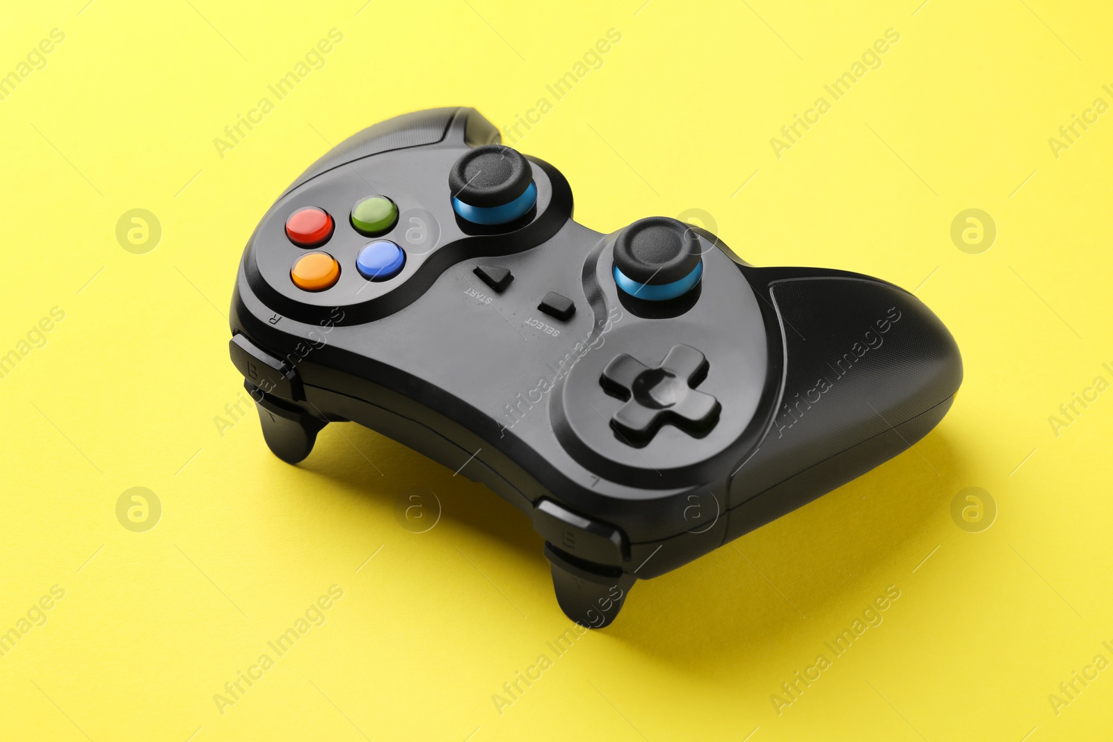 Photo of One wireless game controller on yellow background