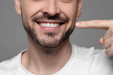 Photo of Man showing healthy gums on gray background, closeup