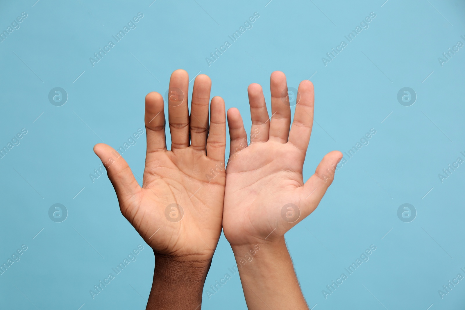 Photo of Men showing hands on light blue background, closeup