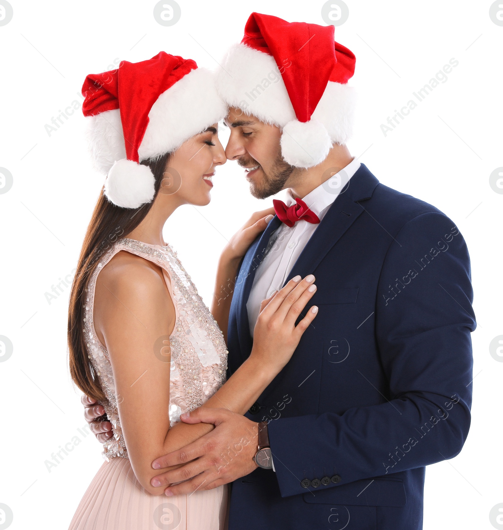 Photo of Lovely young couple in Santa hats on white background. Christmas celebration