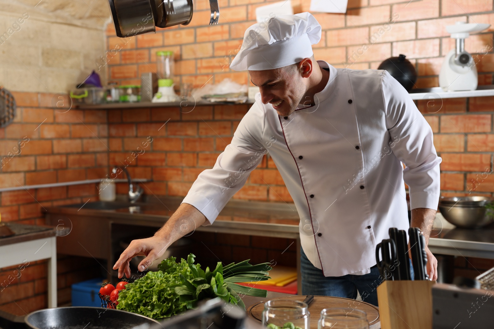 Photo of Professional chef cooking vegetables in restaurant kitchen