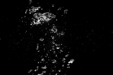 Air bubbles in water on black background