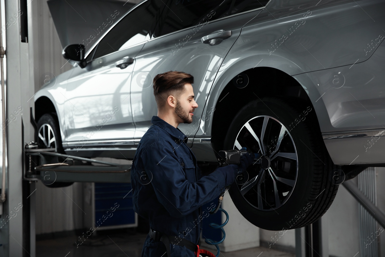 Photo of Technician working with car in automobile repair shop