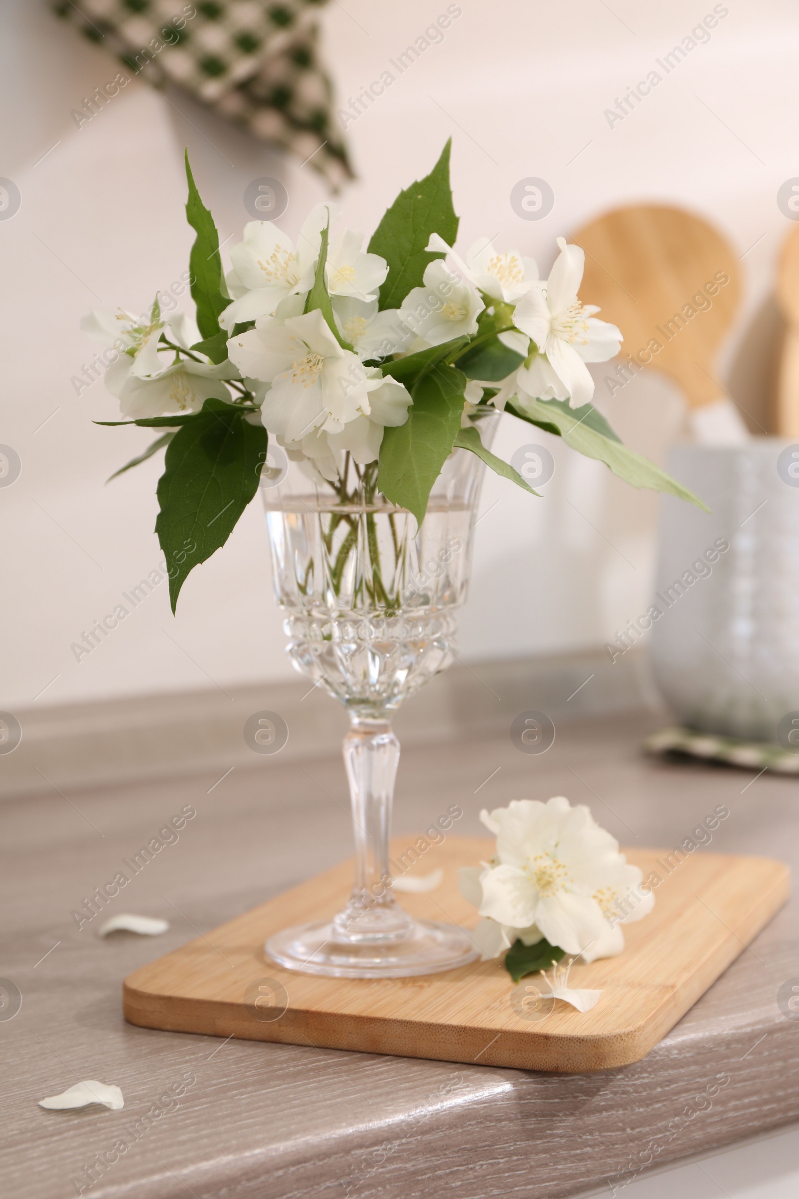 Photo of Beautiful jasmine flowers on wooden table indoors